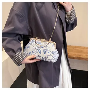 Detail view of Chinese retro crossbody bag with blue floral pattern and gold metal frame