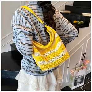 Detail of yellow striped mesh tote bag with smooth leather strap and metal ring