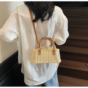 Detalle de bolso de paja trenzada con asa de bambú y bolsa interior con cordón