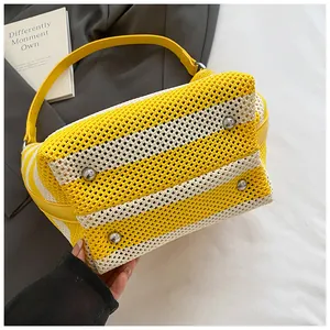 Detail of yellow knit beach bag with silver metal feet and woven grid texture