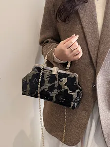 Elegant black and gold jacquard handbag with vintage floral pattern and metal handle