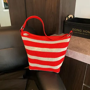 Detailed texture of red and white hollow weave beach bag with silver metal ring buckle