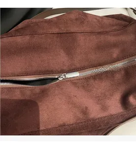 Close-up of smooth silver metal zipper on vintage brown suede tote bag detail