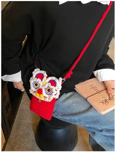 Détail du sac de danse du lion crocheté à la main avec texture de fil rouge et motifs 3D