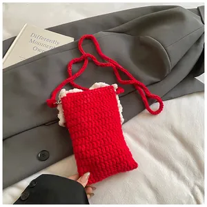 Détail d'un sac bandoulière rouge crocheté à la main avec bordure en peluche et bandoulière