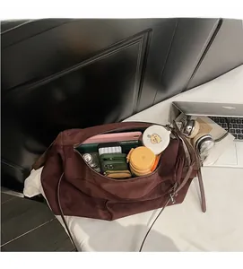 Close-up of spacious interior of brown suede tote bag filled with tablet and essentials