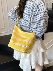 Yellow and white striped mesh tote bag with leather straps for beach and casual summer use