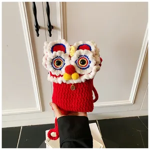 Détail du sac de danse du lion fait main au crochet avec tricot rouge festif et breloque