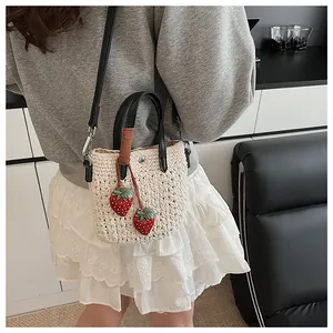 Détail du sac de plage tissé avec des breloques fraises mignonnes et un fermoir magnétique en métal