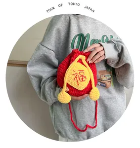 Detail of a handmade crochet lucky bag featuring a red Fu character and yellow tassels
