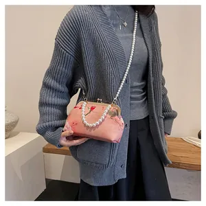 Detailed view of pink floral embroidery bag with pearls and delicate bird motif