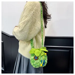 Close-up of green hand-woven pineapple crossbody bag showing textured knit and cute leaf detail