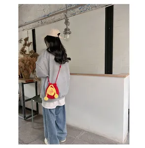 Lifestyle view of red crochet fortune bag with yellow Fu character and pompon details