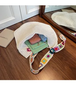 Innenansicht der weißen Häkeltasche mit buntem Blumenriemen und Alltagsgegenständen