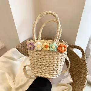Dettaglio di fiori in maglia colorati su una borsa a secchiello in paglia fatta a mano