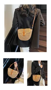 Vue détaillée du sac besace en paille tressée avec bandoulière en cuir et boucle