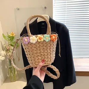 Dettaglio borsa di paglia intrecciata a mano con fiori all'uncinetto e manico a cerchio