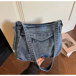 Gros plan d'un sac cabas en denim vintage avec broderie de lettres et design plissé