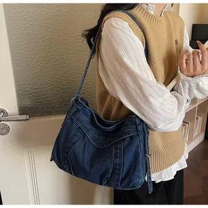 Détail du cabas en denim vintage avec tissu plissé unique et broderie de lettres