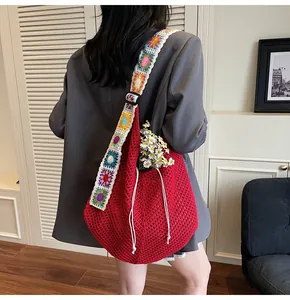 Detailed close-up of a red woven tote bag with a floral crochet wide shoulder strap