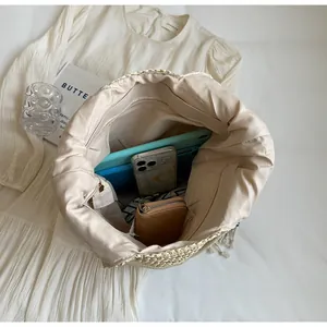 Interior view of large beige woven tote bag showing internal zipper pocket and storage capacity