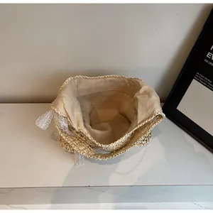 Détail de l'intérieur du sac tissé beige avec doublure en tissu et dentelle fine