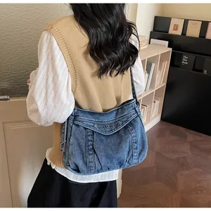 Gros plan sur un sac fourre-tout en denim bleu avec broderie et texture délavée