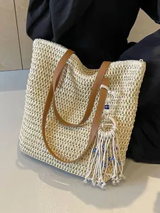 Ethnic straw tote bag in off-white with brown leather straps and evil eye tassel charm