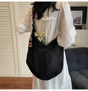 Close-up of black hollow crochet tote bag featuring colorful sunflower shoulder strap
