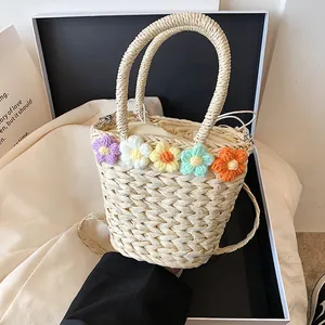Dettaglio borsa a secchiello in paglia con fiori all'uncinetto e fodera interna