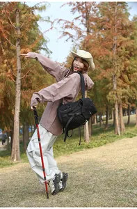 Outdoor-Action-Shooting mit schwarzem Wanderrucksack, Trekkingstöcken und Ausrüstung