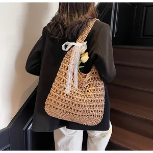 Détail du sac à bandoulière en paille tissé avec nœud en dentelle blanche et tulipe