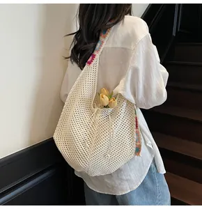 Detail of woven mesh tote with colorful crochet floral shoulder strap and drawstring
