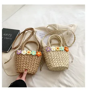 Dettaglio borse tote in paglia intrecciata a mano con fiori all'uncinetto e cordoncino