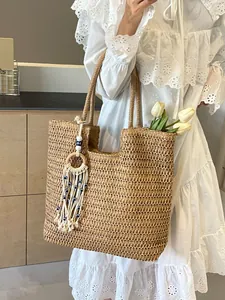 Large woven beach tote bag with white tassel and blue eye charm on a lace dress
