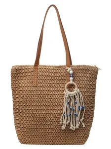 Straw woven beach tote bag with leather straps and evil eye tassel charm in brown