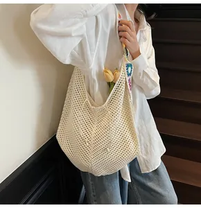 Detail of white hollow woven tote bag with colorful ethnic embroidered shoulder strap