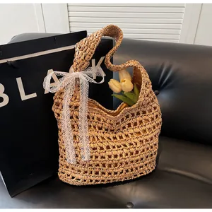 Détail du sac en paille tressée avec un nœud en dentelle blanche et texture naturelle