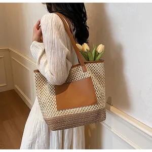 Dettaglio della borsa tote in paglia intrecciata con tasca in pelle e ampio design