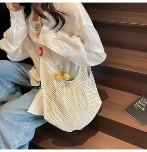 White woven hobo bag with colorful crochet flower strap shown in a lifestyle setting