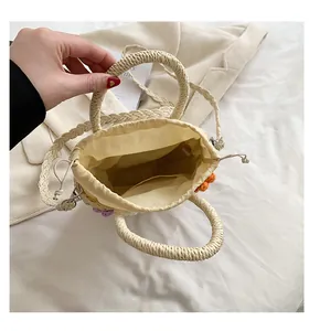 Dettaglio dell'interno della borsa di paglia con fodera a coulisse e fiori crochet