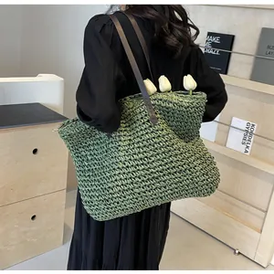 Detail of green straw tote bag with leather straps and woven texture for summer