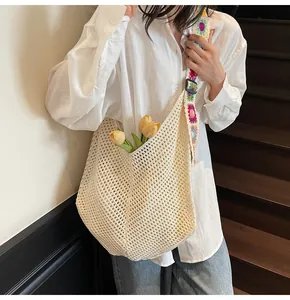 Close-up of beige crochet tote bag with colorful floral strap and yellow tulips