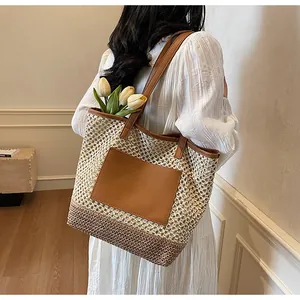Dettaglio di una grande borsa tote in paglia con patchwork in pelle marrone per la spiaggia