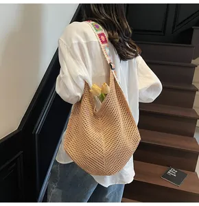 Detail of hand-woven tote bag with colorful crochet floral shoulder strap and beige hobo body