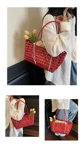 Macro shot of red woven hollow shoulder bag with a beige drawstring lining and long strap