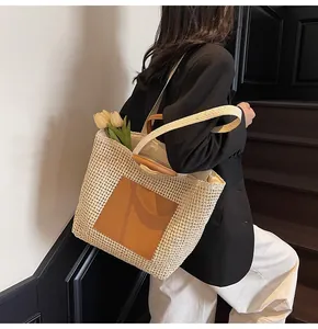 Detailaufnahme der handgewebten Strohtasche mit braunen Ledergriffen und Innenfutter