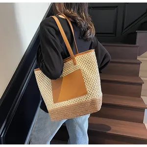 Dettaglio della borsa tote intrecciata con tasca e tracolla in pelle su una donna