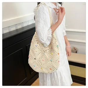 Detail of beige crochet tote bag featuring vibrant candy-colored beads and hollow knit texture
