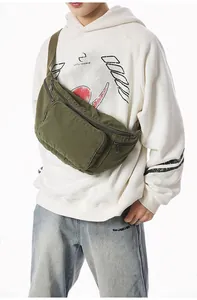 Detail of army green canvas crossbody bag with adjustable strap and dual metal zippers